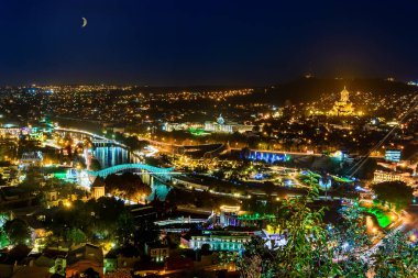 Tiflis 'in panoramik gece görüşünde Hilal Ağdası. Tiflis 'teki Kutsal Üçleme Katedrali, Tsminda Sameba