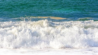 Sea wave with foam and spray during a storm. The concept of tension and struggle.
