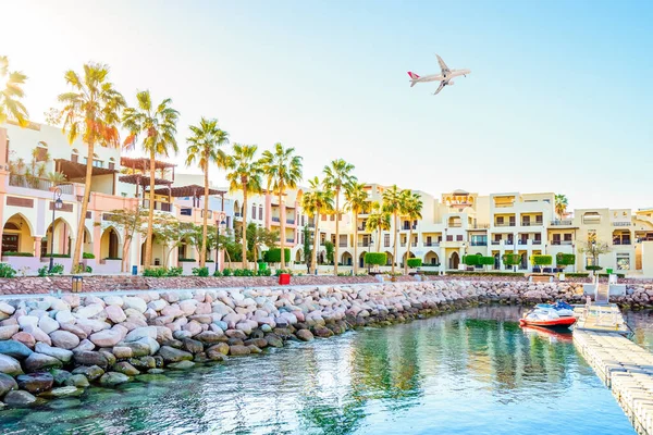 AQABA, JORDAN.  White passenger plane flying over the port of Aqaba located on Red Sea.