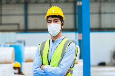 Mühendisler ve ustabaşı maske, şapka ve yelek giyerler. Endüstriyel üretim yönetimi hakkında görüşeceğim. İş detaylarını fabrikalarda veya depolarda dizüstü bilgisayarlar ve tabletler yoluyla açıklamak.
