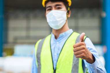 Mühendisler ve ustabaşı maske, şapka ve yelek giyerler. Endüstriyel üretim yönetimi hakkında görüşeceğim. İş detaylarını fabrikalarda veya depolarda dizüstü bilgisayarlar ve tabletler yoluyla açıklamak.