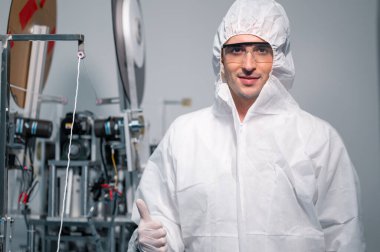 Koruyucu giysi giyen bilim adamları, endüstriyel bir fabrikanın laboratuarında maske yapan bilim adamları. Anti-virüs üretim deposu. Güvenlik ve önleme konsepti Coronavirus covid-19.