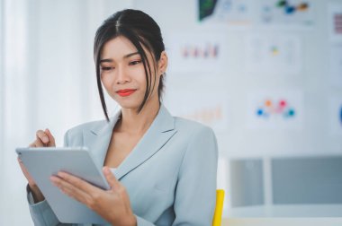 İş kadını, toplantı odasında gülen yüzlü bir arkadaşla tablet ekranda çizelgeleri ve grafikleri tartışıyor. Beyin fırtınası ve takım çalışması konsepti.