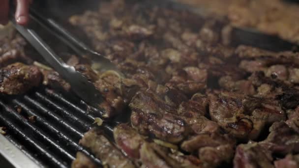 A séf húst süt a grillre. Grillezett hús grillen, közelről. Bárány vagy sertés grillezés. Sok hús van az ételfesztiválon.. — Stock videók