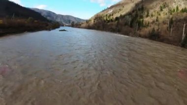 Dağları, dağları olan bir vadi. Evleri, patikaları, bulutları olan mavi gökyüzü olan bir şehrin arka planında bir orman.