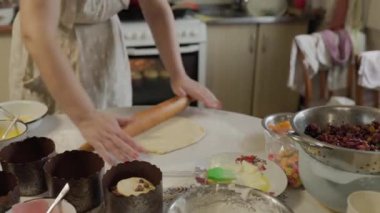 Kadın ağır çekimde merdaneyle çiğ hamur atıyor. Hamuru pişirmek için hazırlıyorum. İnce bir fırın tabağı yapıyorum. Pişirme ve şekerleme hazırlama aşamaları.