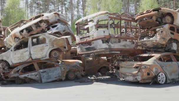 Irpin, Kyiv region, Ukraine - 6 May 2022: Car graveyard in Irpin, consequences of the invasion of the Russian army in Ukraine. Destroyed cars of civilian population. burned cars — Stok video