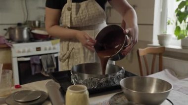 Kadın bisküvi hamurunu yakın plan bir yemek tabağına döküyor. Ev yapımı yemek.
