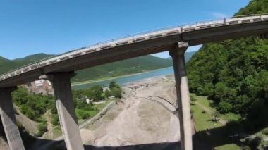 Georgia, Gudauri, yaz mevsimi. Aragvi nehrinin üst görüntüsü. Kafkas dağlarının havadan görünüşü. Köprünün altında bir kuadkopter uçurmak