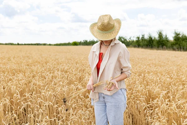 Žena Klobouku Stojící Zlatém Pšeničném Poli Rukou Drží Kytici Hřeby — Stock fotografie