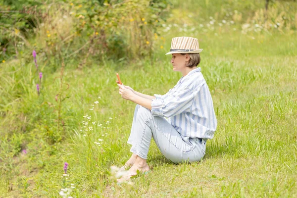 Woman Wearing Hat Sitting Park Green Grass Smartphone Distant Work — Stock Photo, Image