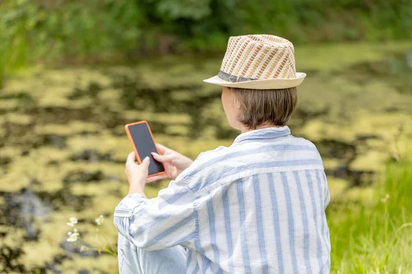 Woman Wearing Hat Sitting Park Green Grass Smartphone Distant Work — Stock Fotó