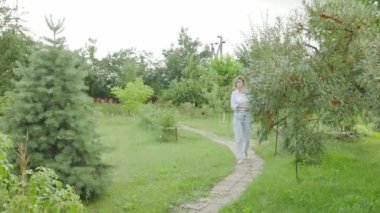 Carefree and easygoing woman walking at city park pathway or garden, carry notebook. rest after a hard day's work