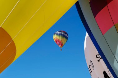 Hot air balloons in the foreground and one in the distance
