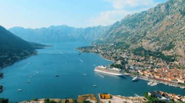 Karadağ. Drone. Kotor Körfezi üzerinde uçuş. Kamera soldan sağa hareket eder. Adriyatik Denizi 'ndeki en büyük körfez. Avrupa 'nın en güneyindeki fiyort. Otoparkta bir yolcu gemisi var.