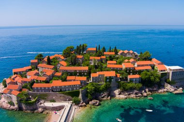 Karadağ. Adriyatik Denizi. Ada ve Sveti Stefan plajı. Yaz. Güneşli bir hava. En iyi sezon. Çok popüler bir turistik yer. Drone. Hava görünümü