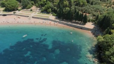 Karadağ. Adriyatik Denizi. Milocer plajı. Yaz. Güneşli bir hava. En iyi sezon. Çok popüler bir turistik yer. Drone. Uçuş. Kamera sağdan sola hareket ediyor.