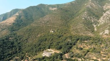 Karadağ. Dağlarda terk edilmiş bir Katolik kilisesi. Drone. Hava görüntüsü. Uç! Kamera ileri gidiyor.