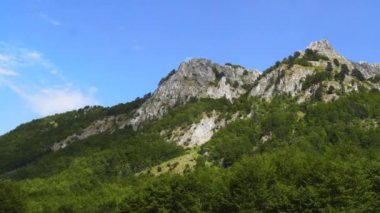 Montenegro. Prokletiye National Park. Summer. Mountain range. Green mountain peaks. Panorama. The camera moves from left to right