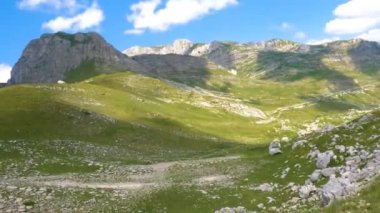 Karadağ. Durmitor Ulusal Parkı. Eyer Geçidi. Alp çayırları. Dağ manzarası. Çekimler yolda geçen bir arabadan yapılıyor.
