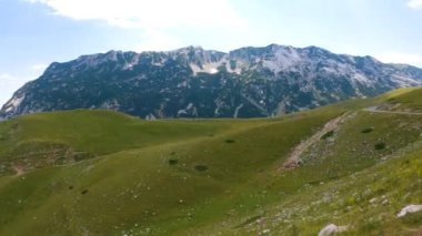 Karadağ. Durmitor Ulusal Parkı. Eyer Geçidi. Alp çayırları. Dağ manzarası. Panorama. Kamera sağdan sola hareket ediyor.