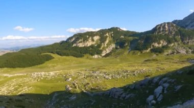 Karadağ. Durmitor Ulusal Parkı. Eyer Geçidi. Alp çayırları. Dağ manzarası. Çekimler yolda geçen bir arabadan yapılıyor.