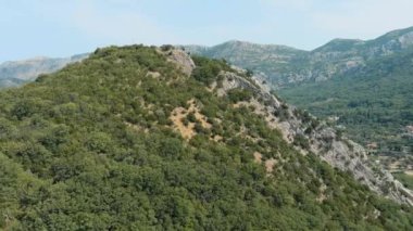 Karadağ. Yaz. Yeşil dağlar. Dağ zirvesi. Drone. Hava görüntüsü. Kamera ileri gidiyor.