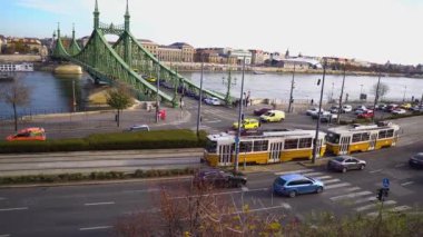 Macaristan. Budapeşte şehri. Tuna Nehri ve Özgürlük Köprüsü 'nün Panorama' sı. Şehir caddesi boyunca araba trafiği. Sabit kamera