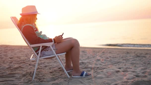 Άδεια Αμμώδης Παραλία Ξημέρωμα Ηλιοβασίλεμα Ένα Κορίτσι Καπέλο Κάθεται Μια — Αρχείο Βίντεο