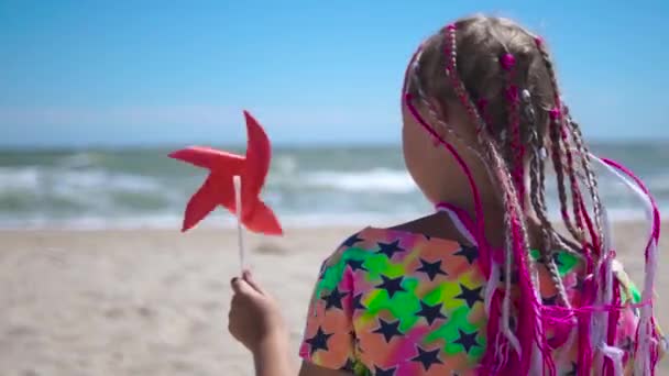 Uma Menina Com Tranças Africanas Rosa Senta Uma Praia Areia — Vídeo de Stock