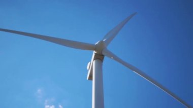 Mavi gökyüzüne karşı rüzgar jeneratörü. Yakın plan. Yeşil enerji. Güneşli bir gün. Sabit Kamera