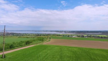 Ukrayna. Bahar. Kırsal kesimde. Yeşil alan. Arka planda bir nehir akıyor. Drone. Hava görüntüsü. Kamera yukarı hareket ediyor..