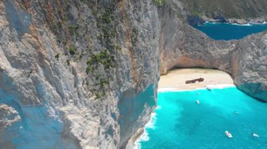 Yunanistan. Zakynthos Adası. İyon Denizi kıyısında. Navagio plajı (gemi enkazı plajı). Popüler turist mekanı. Drone. Hava görüntüsü. Kamera soldan sağa hareket ediyor.