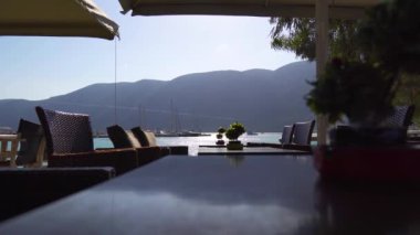 Yunanistan. İyon Denizi kıyısında. Deniz kenarındaki boş sokak kafesi. Deniz kenarındaki dolgu sehpasında bir masa. Sabit Kamera