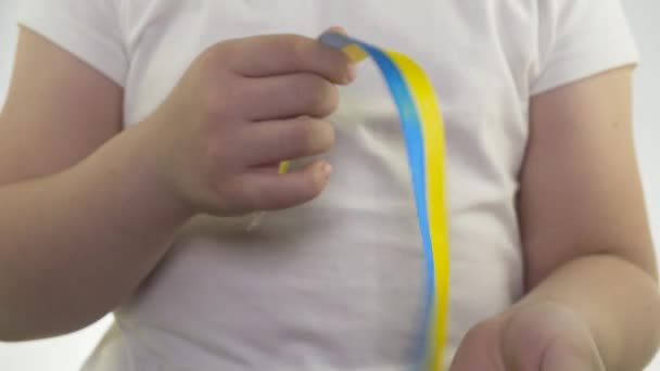Beyaz Tişörtlü Bir Kız Elinde Sarı Mavi Bir Kurdele Tutuyor — Stok video