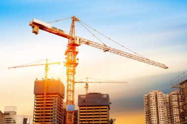 Mavi gökyüzüne karşı vinç ve inşaat alanı