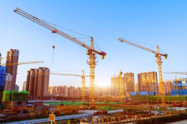 Gökyüzüne karşı kule vinçlerinin siluetleri. Ev yapım aşamasında. Endüstriyel gökyüzü