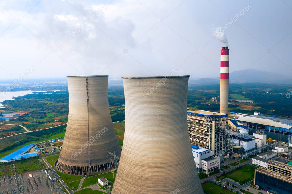coal fired power station with cooling towers releasing steam into atmosphere