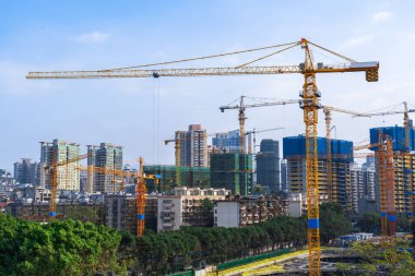 Gökyüzüne karşı kule vinçlerinin siluetleri. Ev yapım aşamasında. Endüstriyel gökyüzü