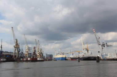 ALMANY, HAMBURG - 2017 AĞUSTOS, Hamburg Alman limanındaki kargo gemileri yükleme ve boşaltma için demirli konteyner terminali. 