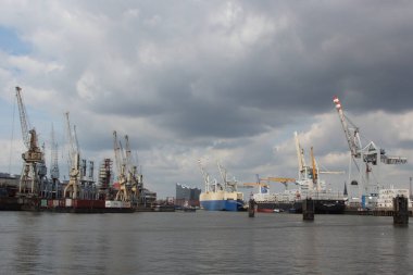 ALMANY, HAMBURG - 2017 AĞUSTOS, Hamburg Alman limanındaki kargo gemileri yükleme ve boşaltma için demirli konteyner terminali. 