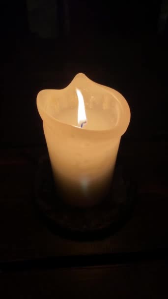 The flame of one large yellow candle lights up, isolated on a black background. Slow motion, central frame close-up. — Stockvideo