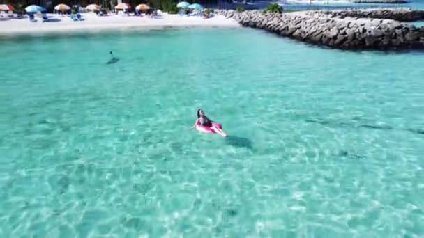 Plaża wakacje kobieta relaks w basenie pływak pączek dmuchany pierścień pływający na turkusowym tle wody oceanu na Malediwach podróży latem. Widok z góry drona. — Wideo stockowe