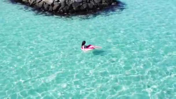 Frau im Bikini ruht auf aufblasbarem Schwimmring Donut in einem Pool mit blauem Wasser. Konzept von Reisen, Urlaub, Wochenenden, Urlaub am Meer Malediven — Stockvideo