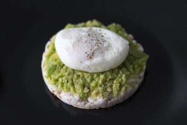 Kahvaltıda. Koyu siyah arkaplanlı yumurta ve Avokado Sandviçi..