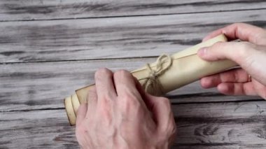 Adam parşömeni açar. Erkeklerin Eli Eski Antika Parşömeni 'ni açıyor. Parşömenin içi boş.