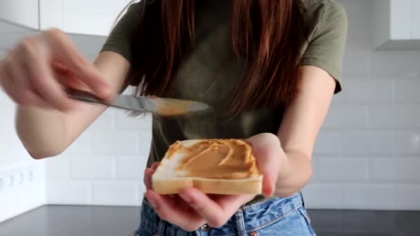 Mujer Joven Hace Sándwich Pan Tostado Mantequilla Maní Cocina — Vídeo de stock