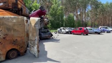Saldırılardan sonra araba mezarlığında bir sürü kırık ve yanmış araba var. Ukrayna 'daki Rus ordusunun işgalinin sonuçları..