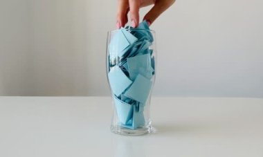 Kadınların eli camdan rastgele bir kağıt parçası alır. Bir sürü mavi etiket..