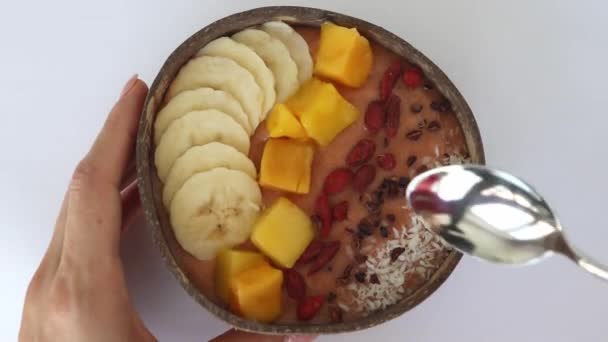 Miska Pomarańczowego Smoothie Świeżym Mango Płatki Kokosowe Banan Zgniecione Ziarna — Wideo stockowe